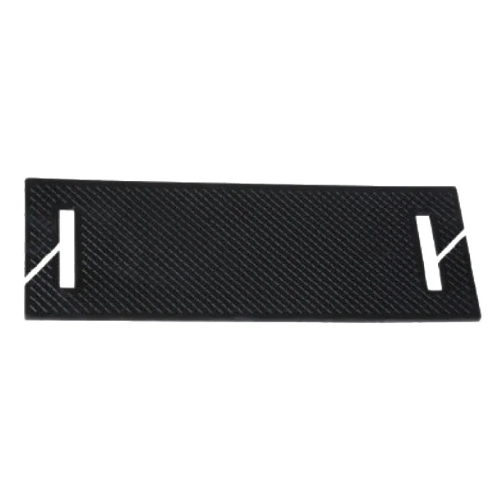 Black textured rectangular plate with diagonal pattern and white stylized end markers on both sides, showing cutouts.