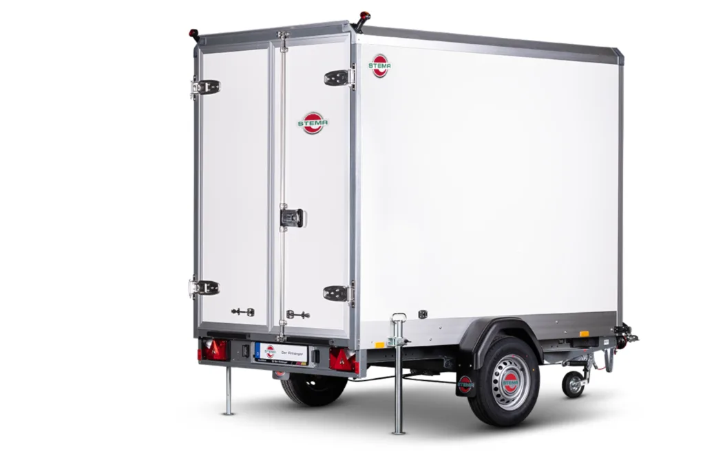 White enclosed cargo trailer with double rear doors, stabilizing legs down, and a single axle beneath a metal frame.