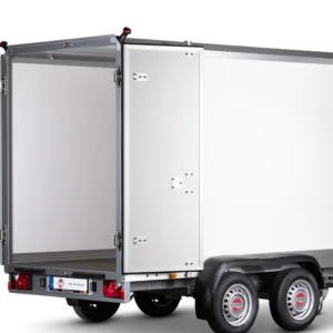 Silver cargo trailer with rear doors open, showing a large white interior, mounted on a dual-axle chassis with red taillights and a small license plate area at the back.