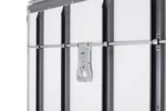 Close-up of a metal latch and horizontal locking bar securing a white industrial door.